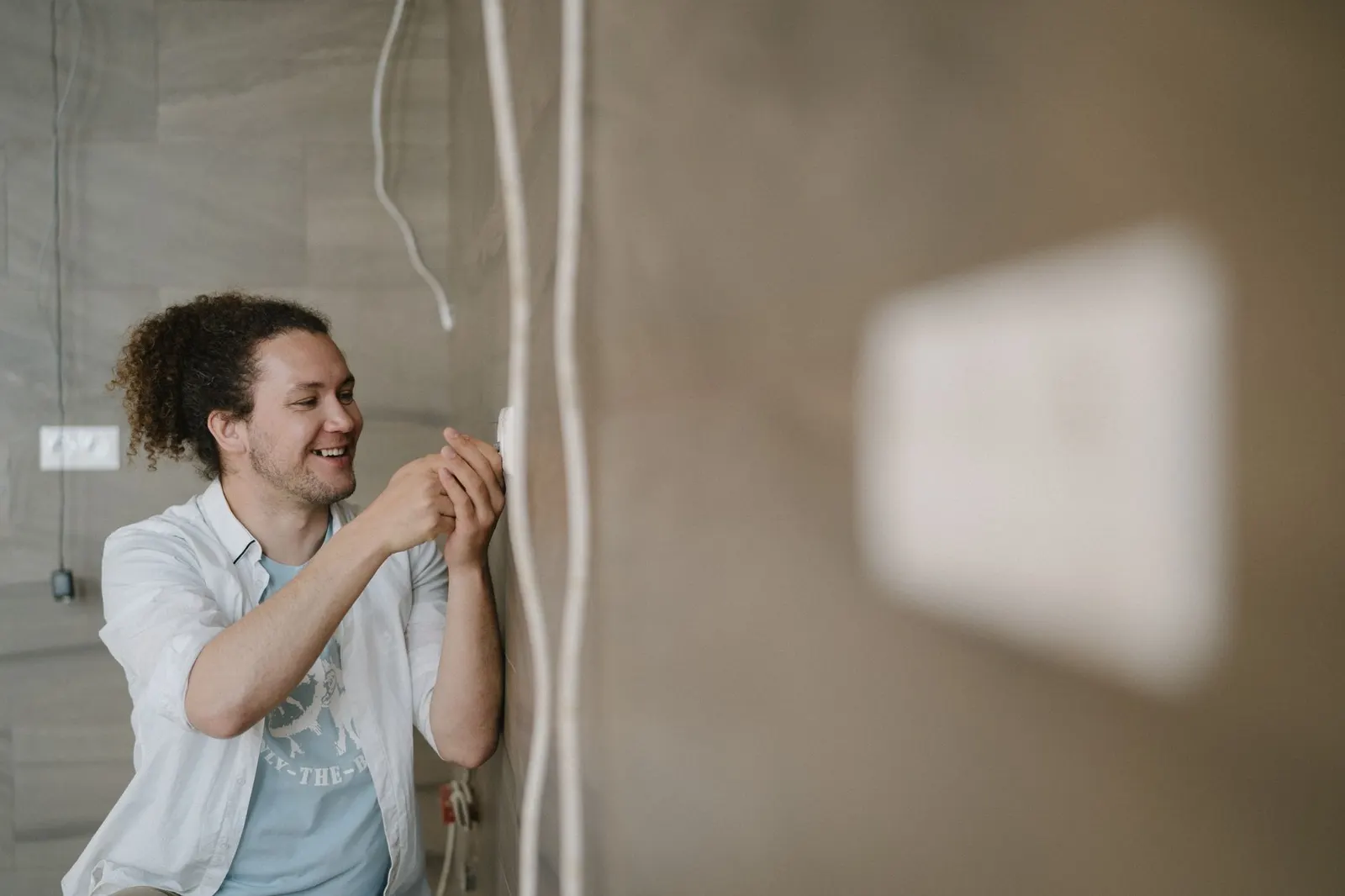 Electrician repairing a wall outlet in a Los Angeles home